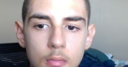 Portrait of a young person with dark hair in a camo-patterned sweater, showcasing a serious expression in a casual setting.