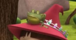 Evie from Mike the Knight wears a magical hat and smiles joyfully, a frog perched on her head in a vibrant forest setting.