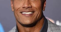 Dwayne Johnson smiles confidently in a stylish suit, showcasing his charisma and presence at a public event.
