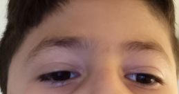 Boy with short brown hair and serious expression, capturing a close-up moment, representing youthful curiosity.