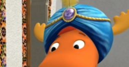 Sultan Tyrone from Backyardigans, dressed in vibrant attire, welcomes guests with a joyful expression in a colorful setting.