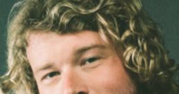 Yung Gravy casually smiling, showcasing his signature style with curly hair and a retro outfit. Engaging and charismatic presence.
