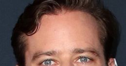 Armie D. Hammer at a red carpet event, showcasing a classic style with short hair and a confident expression.