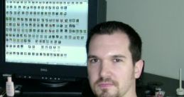 Duncan McKissick seated at a desk with a computer screen displaying game assets, involved in Age of Empires development.