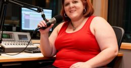 Heather Raina in a recording studio wearing red, sitting with a microphone, showcasing her passion for broadcasting.