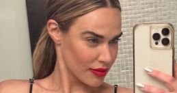 CJ Perry showcases a stylish black bikini and bold red lipstick, highlighting her striking look in this confident selfie.