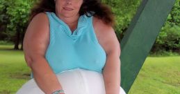 Woman in casual blue top seated outdoors, showcasing confidence and comfort in her style. Celebrating body positivity.