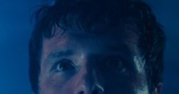 Mike After in a tense moment, showcasing emotion under dramatic blue lighting, highlighting his character's intensity.