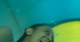 Joyful child laughing while sliding down a colorful indoor slide, showcasing excitement and fun in a playful setting.