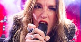 Lzzy Hale passionately performing on stage with her guitar, exuding energy and power during a live concert.