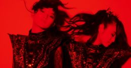 Babymetal performers in striking black and red outfits, showcasing their iconic style and energy against a vivid backdrop.