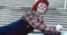 Clown performing a playful pose on steps, showcasing vibrant costume and cheerful expression, embodying joy and entertainment.