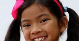 Smiling girl wearing a pink sequined shirt and matching headband, embodying fun and joy from "Emma (Toys And Colors) 2020".