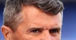 Roy Keane with a thoughtful expression, featuring a neatly groomed beard and wearing a light blue shirt.