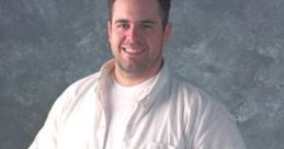 Chea O'Neill from Ensemble Studios, smiling casually in a white shirt and blue jeans against a textured background.