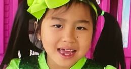 Jannie, dressed in a sparkling green outfit with a bright bow, showcases vibrant colors in a playful setting.