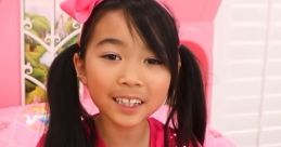 Young girl in a pink outfit holds a tablet, capturing vibrant colors and fun from "Lucy Toys and Colors" Season 1.