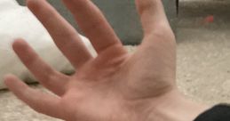 Open hand resting on a soft surface, showcasing fine details of fingers and palm in a cozy setting.