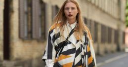 Fashion-forward woman in a chic striped cape, stylishly strolling down a city street, showcasing modern outfit trends.