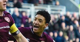 Heart of Midlothian FC players celebrate a goal, showcasing team spirit and passion for club songs and traditions.