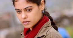 Thoughtful woman in casual attire with a red scarf, expressing emotion related to "Kazhugu" themes.