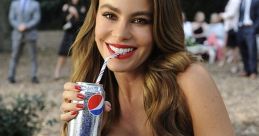 Woman in a blue dress smiles while enjoying a Diet Pepsi at a social event, showcasing a refreshing and stylish moment.