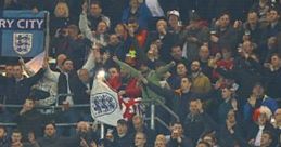 Millwall FC fans passionately showing support with flags and banners during a football match, celebrating club songs.