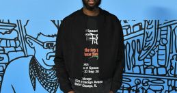 Virgil Abloh poses confidently at the MCA Chicago event, showcasing his unique streetwear style against a vibrant backdrop.
