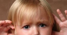 Frustrated child covering ears with hands, expressing annoyance or reaction to teasing or taunting.