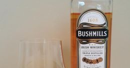 Bushmills Irish whiskey bottle next to a glass of whiskey, showcasing its smooth, mellow golden hue and rich heritage.