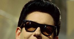 Roy Orbison with iconic sunglasses, showcasing his unique style and charisma, a legendary figure in rock and roll history.