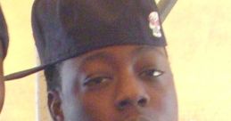 Ace Hood wearing a black cap and purple shirt, showcasing his signature style and confident expression.
