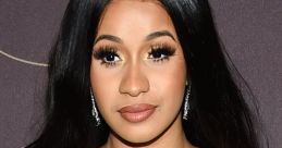 Cardi B stunning in a black off-shoulder dress, showcasing her signature glam and radiant beauty at a red carpet event.