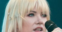 Carly Rae Jepsen performing live, showcasing her signature style with a vibrant red outfit and captivating stage presence.