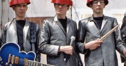 Devo band members in metallic outfits and red hats pose with instruments, showcasing their iconic new wave style.