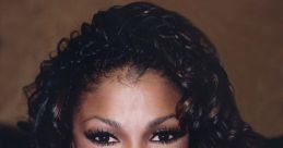 Janet Jackson beams a radiant smile with curly hair, showcasing her iconic style and captivating charm.