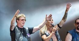 Twisted Sister band members performing live, celebrating with energetic gestures on stage at a rock concert.