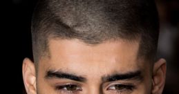 Zayn Malik with a fresh buzz cut, showcasing his defined features and stylish look at a celebrity event.
