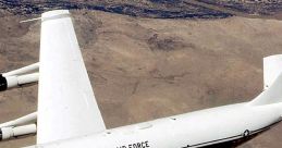 US Air Force aircraft flying over a desert landscape, showcasing its sleek design and military capabilities.