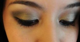 Close-up of a woman with elegant green eyeshadow, natural lips, and a stylish scarf, showcasing a chic makeup look.