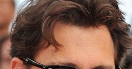 Johnny Depp smiling in stylish sunglasses, showcasing his signature look at a film premiere event, exuding charisma.