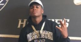 Young man in a Washington hoodie poses confidently, representing school spirit at an official event with a pass.