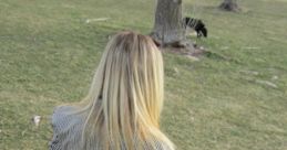 Person in a striped blazer with long hair standing in a grassy field, embodying the relaxed atmosphere of IdiotPantsPod.