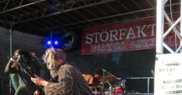 Energetic performance at Störfaktor Festival, featuring a unique band in vibrant costumes and festive decor on stage.