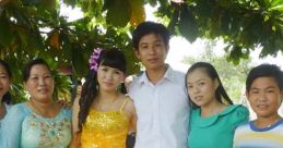 Group of young adults and women in colorful outfits posing together outdoors, celebrating a special occasion under trees.