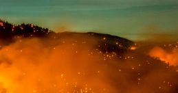 Wildfire engulfs mountainside, illuminating smoke-filled sky with fiery glow, highlighting the destructive force of fire.