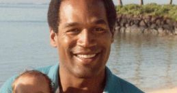 O. J. Simpson smiling while holding a baby adorned with a floral lei on a sunny beach. Family moments captured.