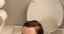Boy's head humorously poking out of a toilet seat, showcasing a quirky and playful bathroom scenario.