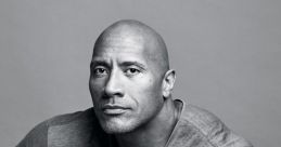 Dwayne Johnson in a stylish gray shirt, showcasing his iconic muscular build and tattoo, exuding confidence and charisma.
