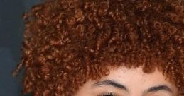 Ice Spice with vibrant curly hair and a stunning necklace, showcasing her unique style and charm at a red carpet event.